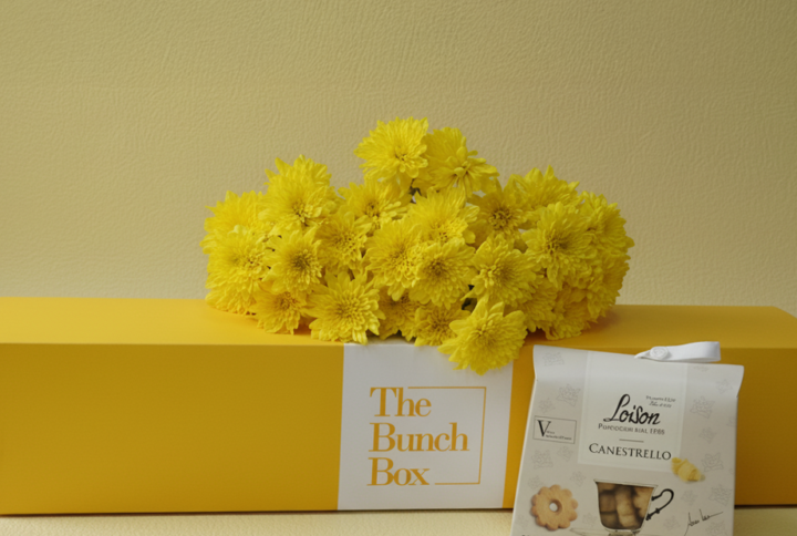 Yellow Bonita and Wafers combines the radiant energy of five Bonita yellow spray chrysanthemums with the buttery richness of 200g Loison Canestrello biscuits. Presented in a color-matched signature gift box, this set offers a professional and spirited gifting solution that blends fresh botanical beauty with the heritage of premium Italian confectionery. Perfect for sharing a moment of sunshine and refined taste.