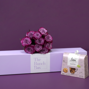 The Purple Rose Tea Time Bundle pairs ten striking deep purple roses with a 200g package of artisanal Loison Zaletto biscuits. Presented in a color-matched signature lavender gift box, this set offers a refined and modern approach to gifting that blends high-end floristry with heritage Italian pastry.