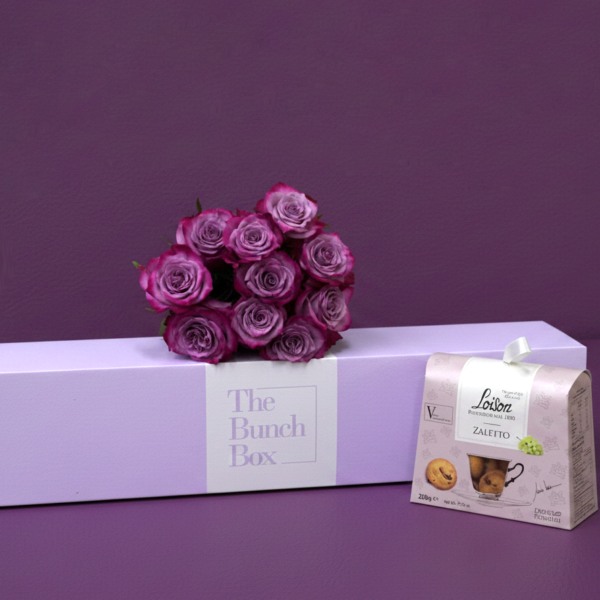 The Purple Rose Tea Time Bundle pairs ten striking deep purple roses with a 200g package of artisanal Loison Zaletto biscuits. Presented in a color-matched signature lavender gift box, this set offers a refined and modern approach to gifting that blends high-end floristry with heritage Italian pastry.